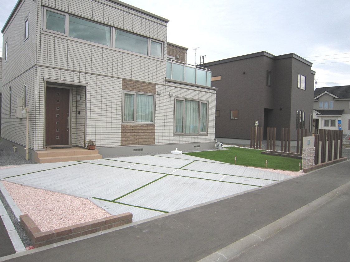 人工芝のラインが入った土間コンクリートでデザインされた駐車スペース