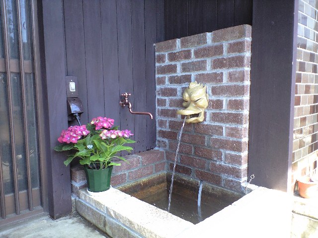 レンガで作られた人工の滝を楽しめる壁泉のある玄関